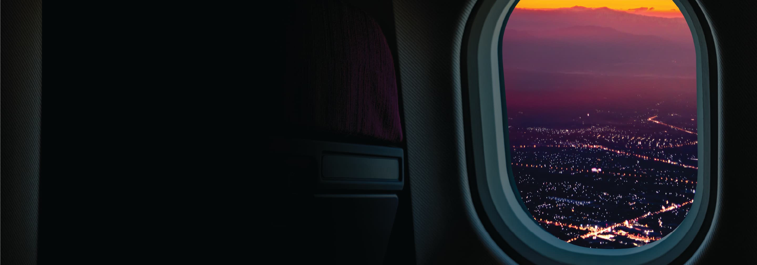 Looking out a plane window at city lights